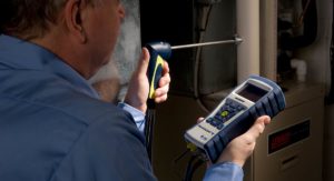 HVAC technician testing residential furnace with Bacharach Insight Plus Combustion Analyzer.