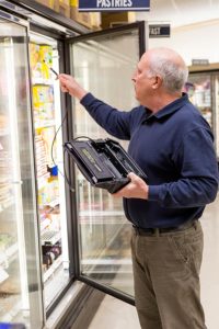 Refrigeration contractor locating refrigerant leak in supermarket.