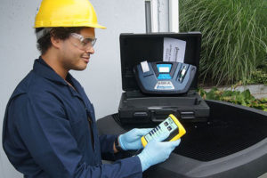 Kỹ thuật viên HVAC phân tích môi chất lạnh R-22 từ máy điều hòa không khí dân dụng.